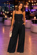 Woman wearing a dark indigo denim corset-style camisole top paired with high-waisted wide-leg pants, styled for an evening event with a modern chic aesthetic.
